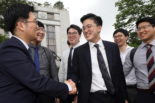 지난 6월 28일 오후 서울 종로구 헌법재판소에서 양심적 병역거부자들이 선고 결과에 기뻐하며 악수하고 있다